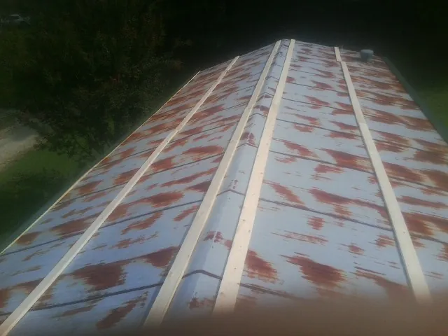 Rusted metal roof panels with new wood purlins before replacement — Storm Damage Roof Repair in Sanbornton by Roofing Brothers