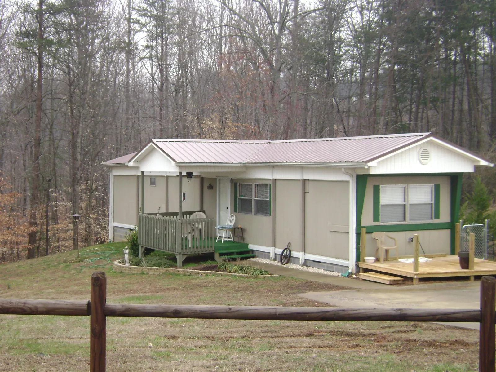 Mauve metal roof on a manufactured home with a new front deck in Sanbornton